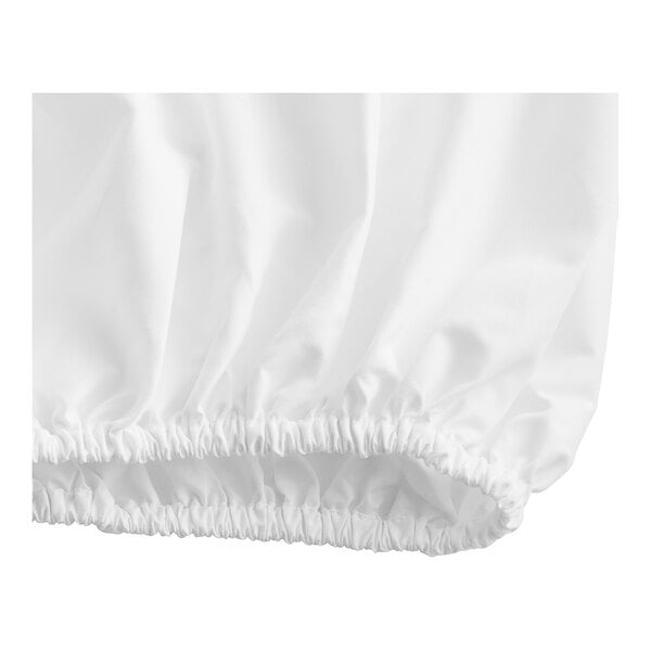 A close-up of a white fabric fitted sheet with ruffled edges.