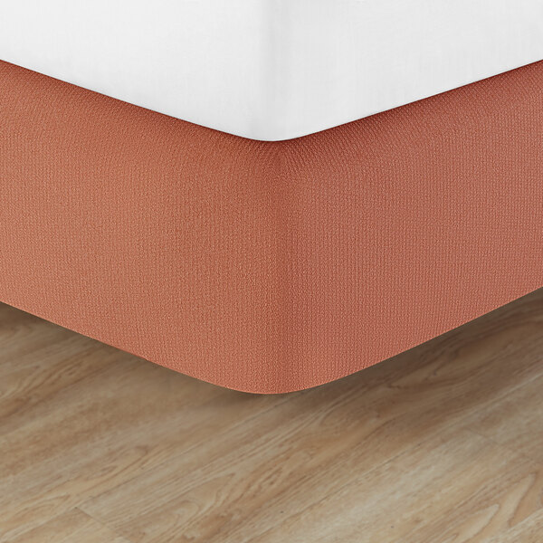 A bed with a Berkshire Hospitality paprika helix box spring cover on it.