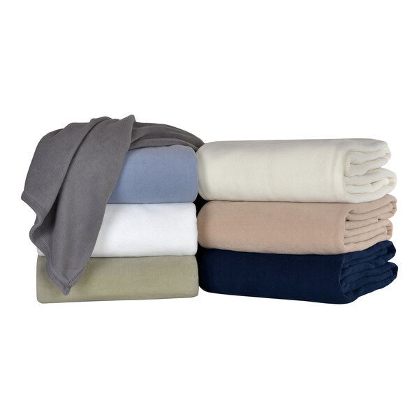A stack of Berkshire Hospitality Microloft smoke colored blankets on a white surface