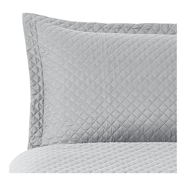 A close up of a grey diamond quilted pillow sham.