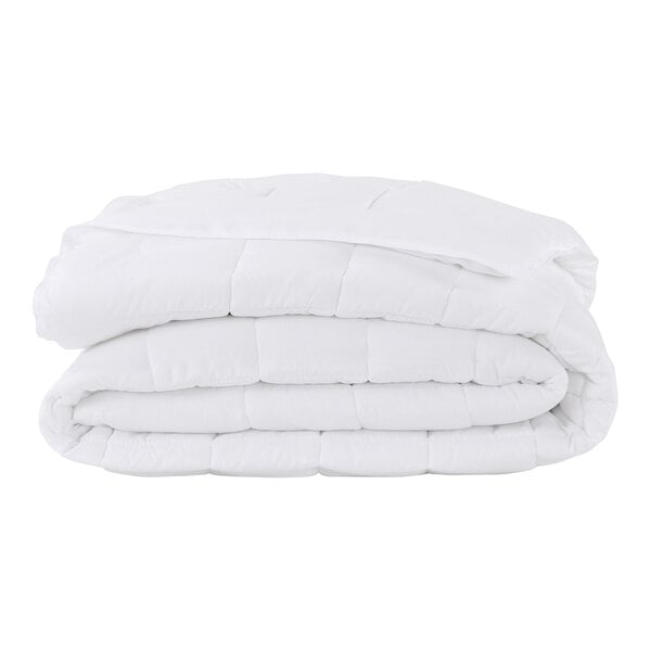 A stack of white Berkshire Hospitality LiteLuxe comforters.