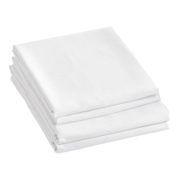 A close-up of a stack of Berkshire Hospitality SuiteDream Twin XL size white sheets.