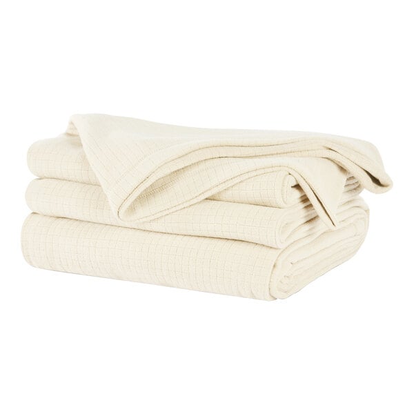 A stack of Berkshire Hospitality cream fleece blankets.