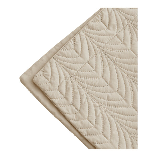 A close up of a beige Berkshire Hospitality quilted pillow sham with a botanical leaf pattern.