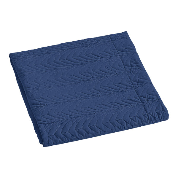 A white pillow sham with blue quilted botanical leaf design.