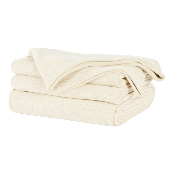 A stack of cream Berkshire Hospitality Polartec Softec king size blankets.