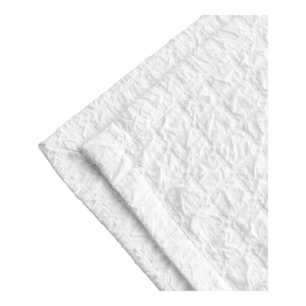 A close-up of a white Berkshire Hospitality King Size Prism Puff Jacquard top sheet folded