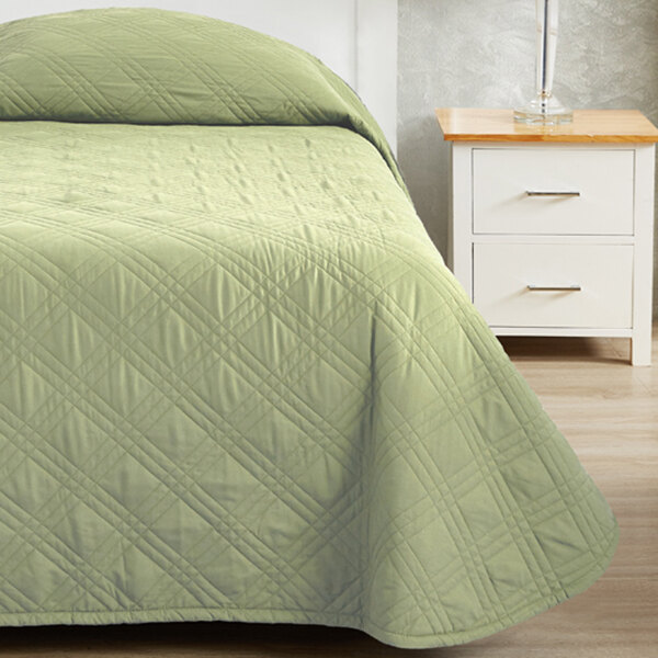 A bed made with a Berkshire Hospitality CozyCare Spa Green bedspread.