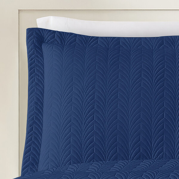 A blue and white Berkshire Hospitality quilted pillow sham with a botanical leaf pattern.