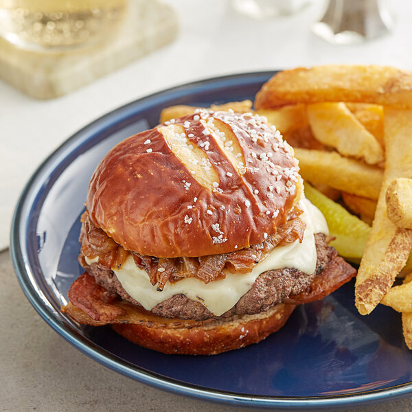 A King's Hawaiian pretzel hamburger roll with a burger and fries on a plate.