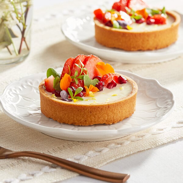 A dessert plate with two Pidy sweet butter tart shells filled with fruit.