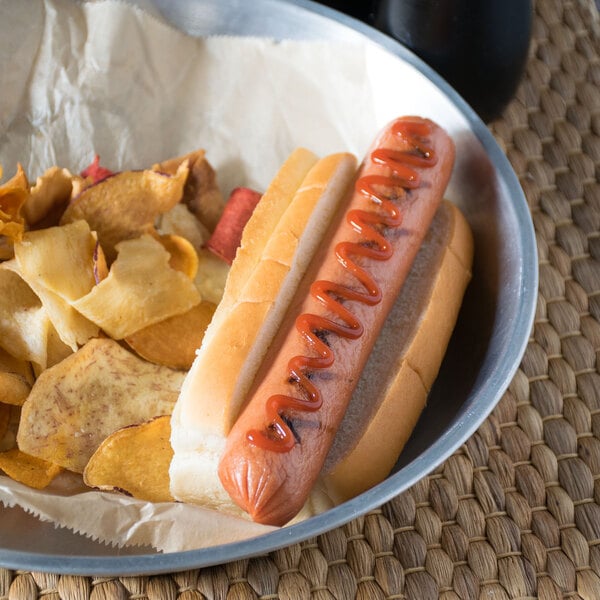 A European Bakers New England hotdog bun with a hotdog and chips on a plate.