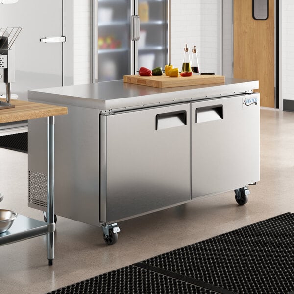 An Avantco undercounter freezer in a stainless steel kitchen with a large counter top.