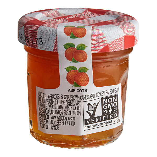 A Bonne Maman mini jar of apricot preserves with a red and white checkered label.