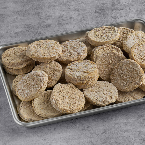 A tray of round brown Hungry Planet vegan breakfast sausage patties on a table.