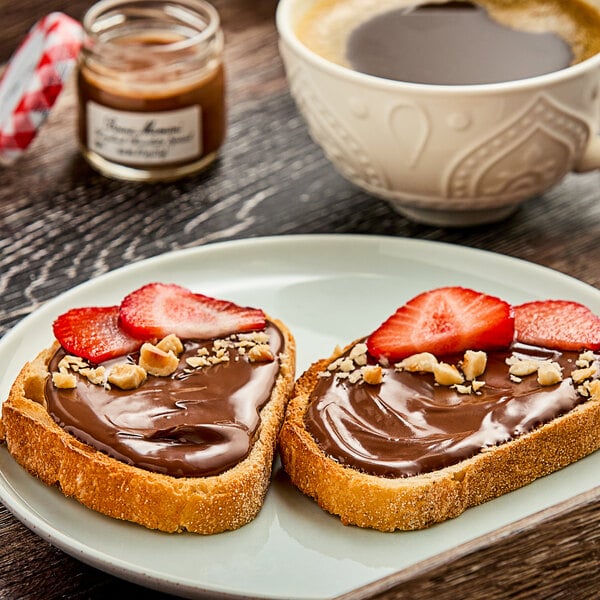 A piece of bread with Bonne Maman Hazelnut Chocolate Spread and strawberries on a white plate.