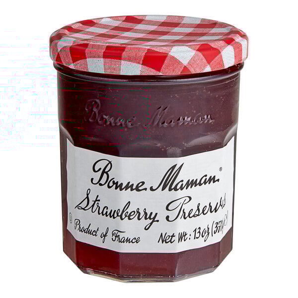 A Bonne Maman strawberry preserves jar with a red and white checkered lid.