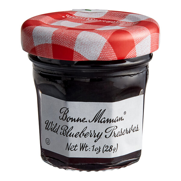 A Bonne Maman mini jar of wild blueberry preserves with a white label and red and white checkered lid.