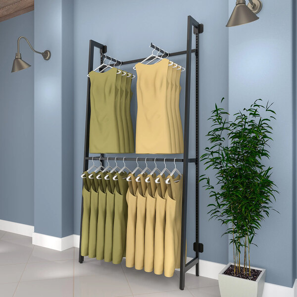 A matte black Econoco wall-mounted retail clothing rack with clothes on hangers.
