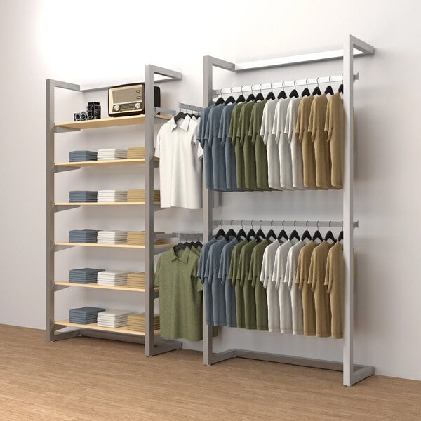 An Econoco wall-mount retail display kit with shelves, hangrails, and faceouts holding clothes.