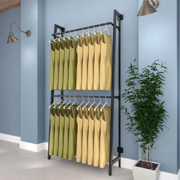 A matte black Econoco wall-mount A-frame retail clothing rack with clothes hanging on it.