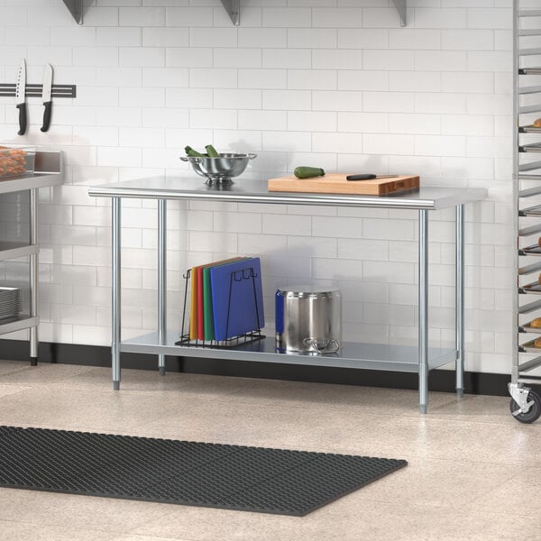 A galvanized steel undershelf attached to a stainless steel work table in a professional kitchen.
