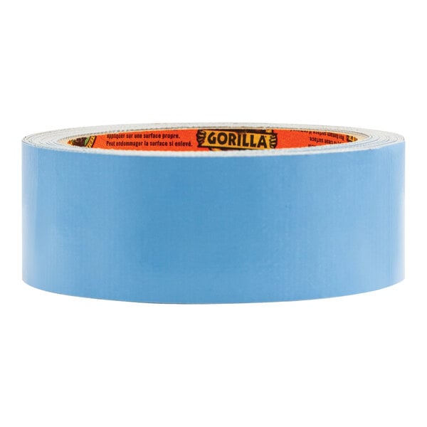 A close-up of a roll of blue Gorilla double-sided tape with orange writing on it.