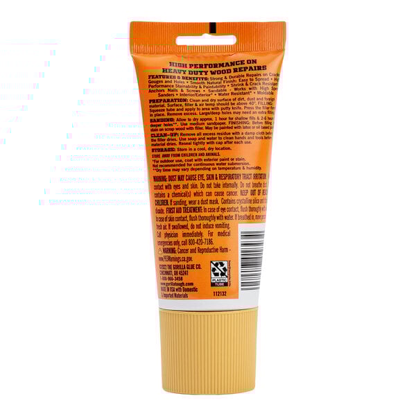 A close-up of a Gorilla Golden Oak wood filler tube with orange and black packaging.