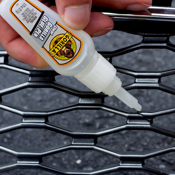 A hand uses a Gorilla Glue pen to fix a tire.