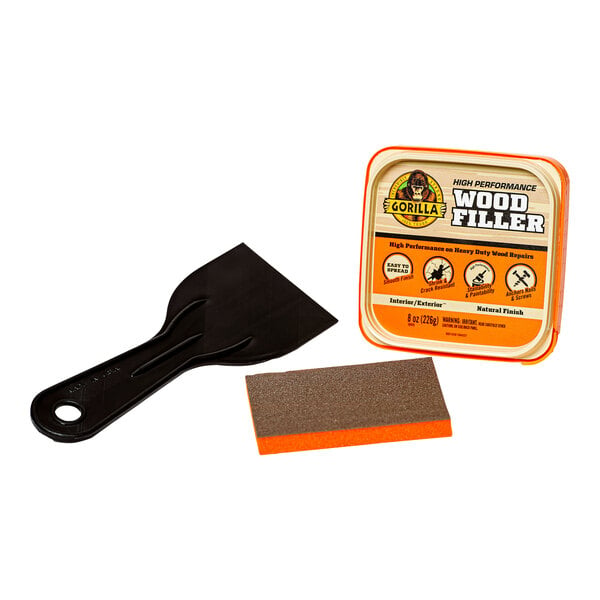 A black and orange Gorilla wood filler kit with a brown sponge and a black spatula.