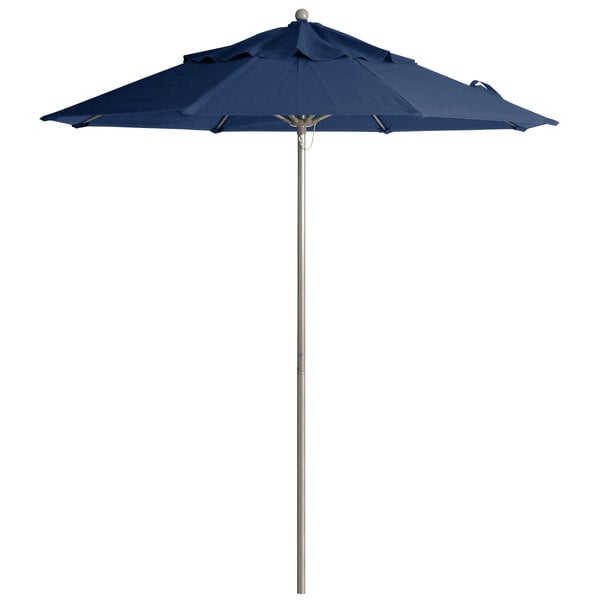 A navy blue Grosfillex Windmaster umbrella on a white pole.