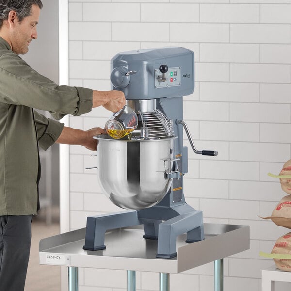 A man using an Ecoline by Hobart 20 quart stand mixer to mix food.