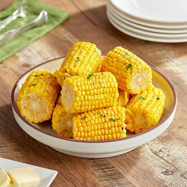 Mini corn on the cob on a plate with butter and salt.