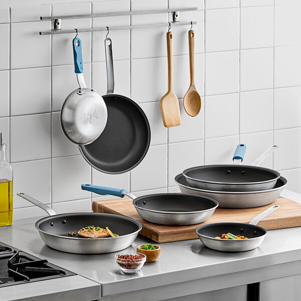 A Vigor A3000 Series aluminum frying pan with a black and silver handle on a counter.