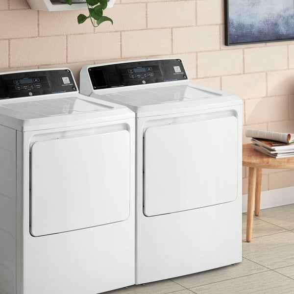 A white GE front load gas-powered commercial dryer.