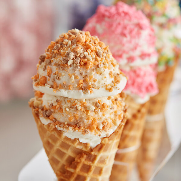 A group of ice cream cones with Yum Crumbs Peach Cobbler crumb topping.