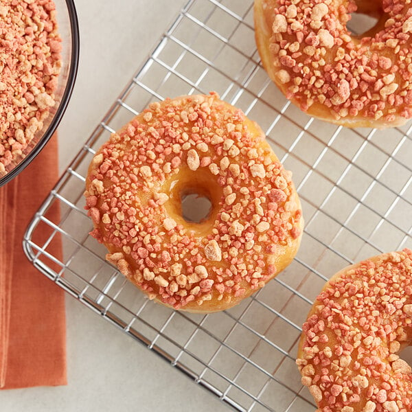 Three donuts with maple bacon crumbles on top.