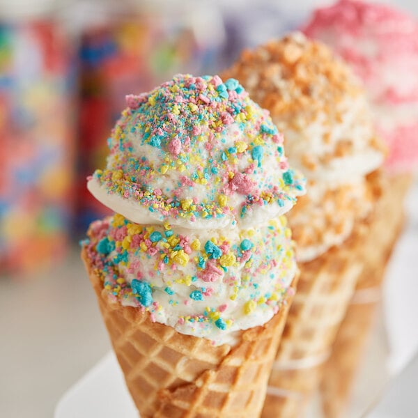 Three ice cream cones with Yum Crumbs Supaman crumb topping and colorful sprinkles.