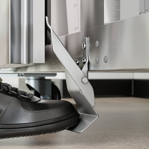 A person's right foot on a metal bracket with a metal piece for Avantco refrigeration equipment.