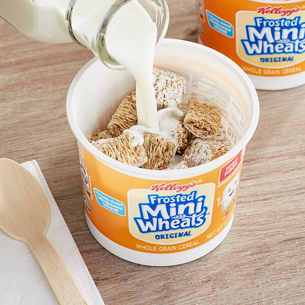 A bowl of Kellogg's Frosted Mini-Wheats Bite Size Cereal with milk and a spoon.