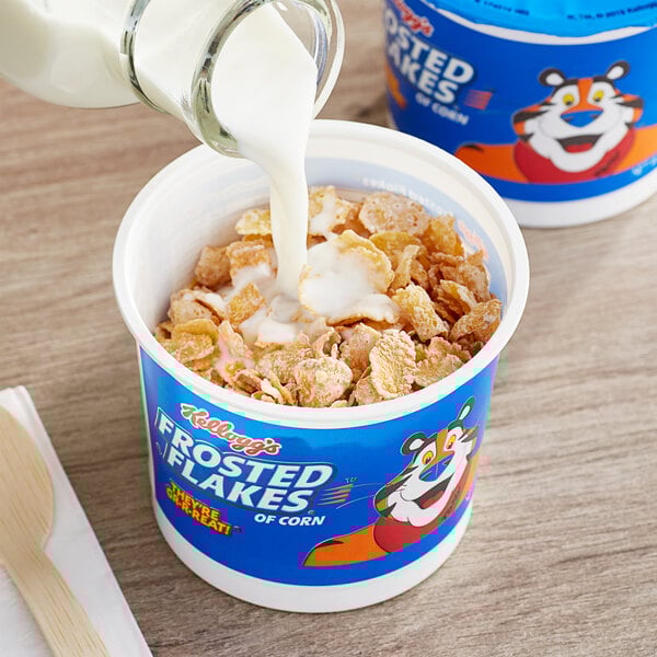 A bowl of Kellogg's Frosted Flakes cereal with milk being poured into it.
