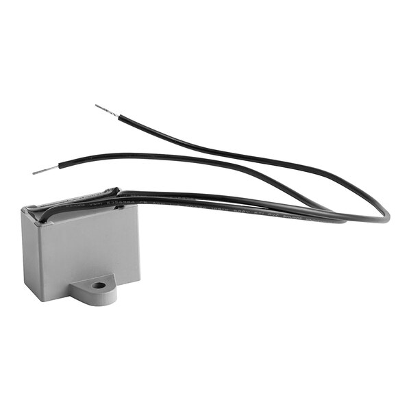 A grey Noble Products capacitor with black and white wires.