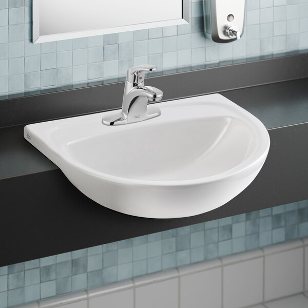 An American Standard white semi-countertop sink with a silver faucet.