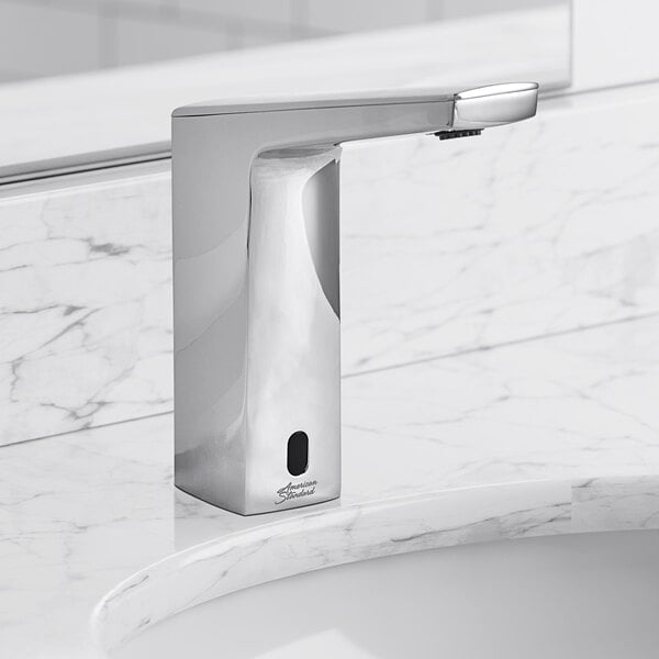 A silver American Standard touchless faucet with a chrome finish on a marble counter.