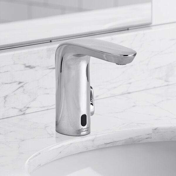 A silver American Standard NextGen Selectronic touchless faucet on a white marble countertop.