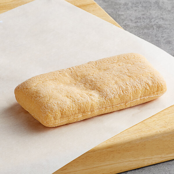 A rectangular Schar Gluten-Free Long Ciabatta Roll on a wooden surface.