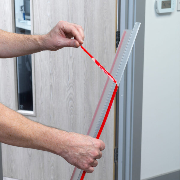 A person measuring a door using a L.A. Baby clear plastic Fingershield.
