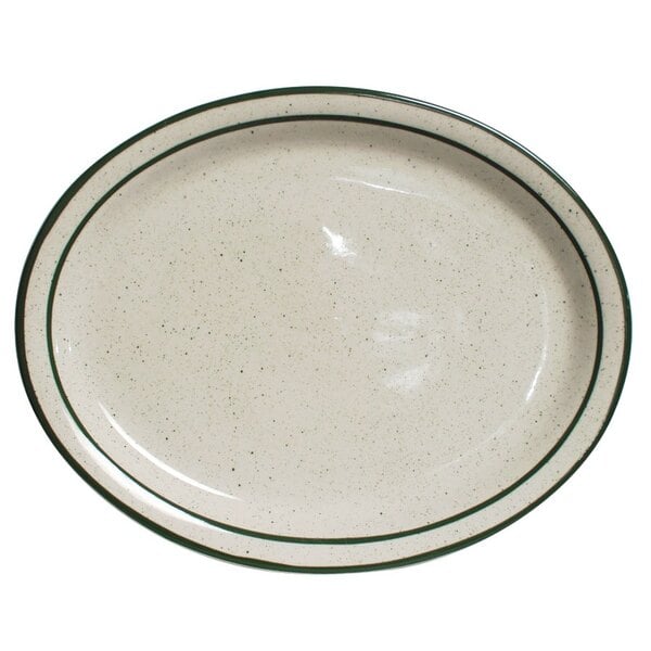 A white Tuxton oval china platter with a green speckled rim.