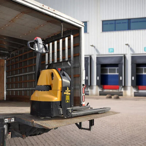 A yellow and black Big Joe electric pallet truck in a trailer.