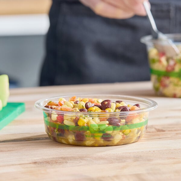 A clear 8 oz. compostable deli container filled with mixed beans and vegetables.